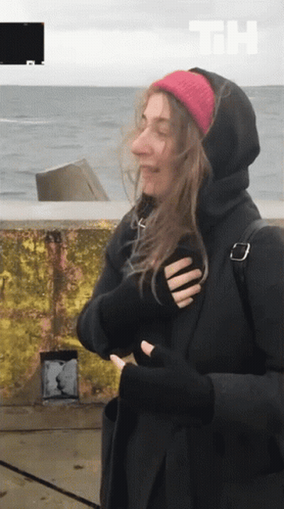 Woman In Black Hoodie And Red Beanie By Ocean GIF