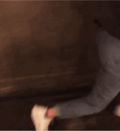 Woman In Black Jacket And Blue Jeans Walking Down Dark Hallway GIF