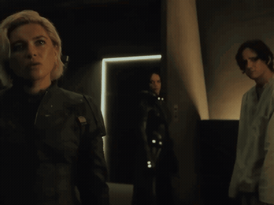 Woman In Black Jacket In Dark Room With Two People GIF