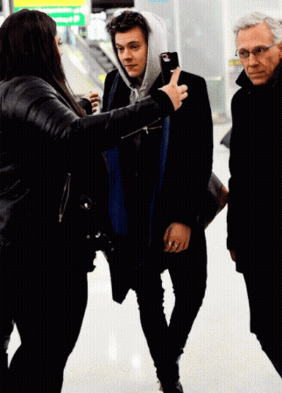 Woman In Black Jacket Photographing Man In Hoodie GIF