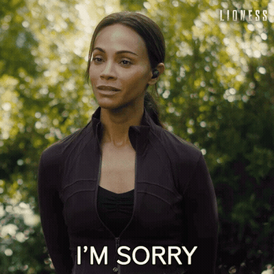 Woman In Black Jacket Says I'm Sorry In Front Of Trees GIF