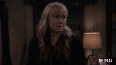 Woman In Black Jacket Standing In Front Of Lamp And Netflix Logo GIF