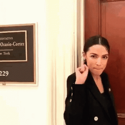 Woman In Black Jacket With Ocasio Cortez Sign GIF