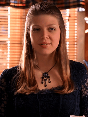 Woman In Black Lace Top And Necklace Smiling GIF
