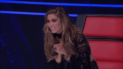 Woman In Black Lace Top Smiling In Red Chair GIF