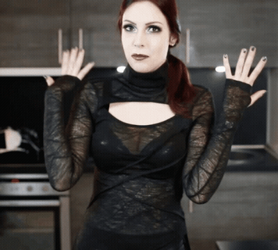 Woman In Black Lace Top With Hands Outstretched In Kitchen GIF
