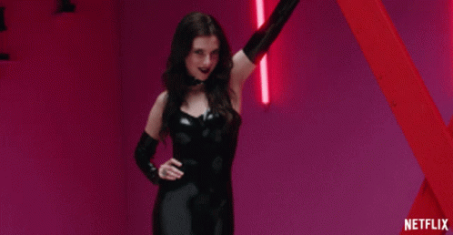 Woman In Black Latex Outfit Standing In Front Of Red Pole With Netflix GIF