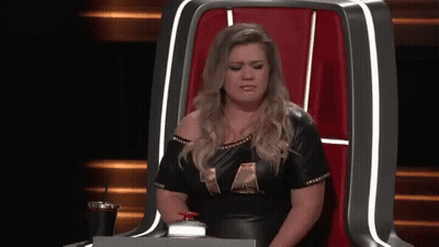 Woman In Black Leather Dress Sitting With Drink GIF