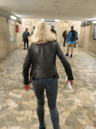 Woman In Black Leather Jacket Approaching Ascensoare Sign GIF