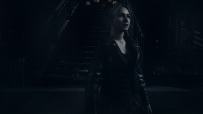 Woman In Black Leather Jacket Standing In Dark GIF