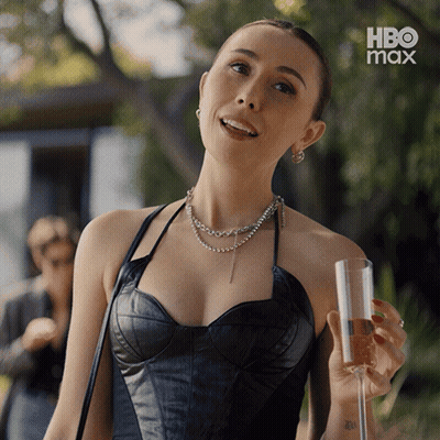 Woman In Black Leather Top Holding Wine In Front Of HBO Max Ad GIF