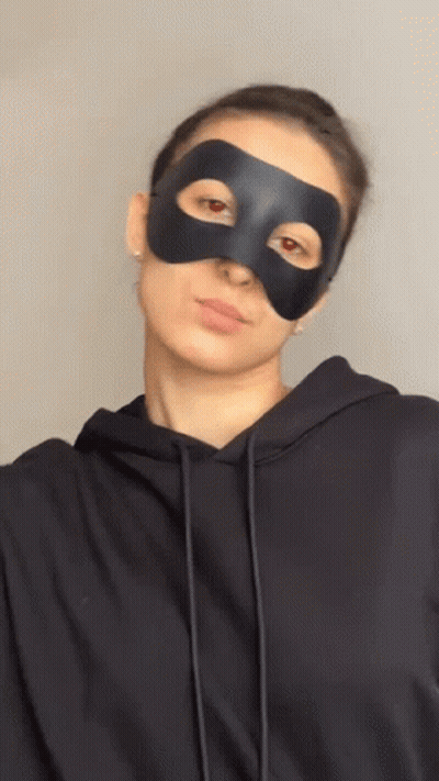 Woman In Black Mask And Hoodie Looking At Camera GIF