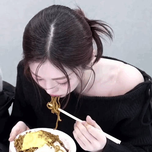 Woman in Black Off-Shoulder Sweater Eating Noodles With Chopsticks
