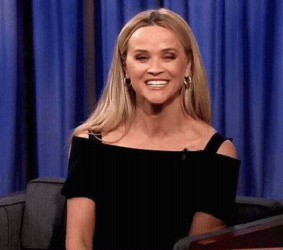 Woman In Black Off-Shoulder Top And Hoop Earrings Smiling GIF
