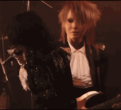 Woman In Black Sequined Jacket Standing Next To Woman GIF