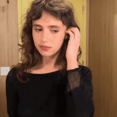 Woman In Black Shirt Adjusting Hair GIF
