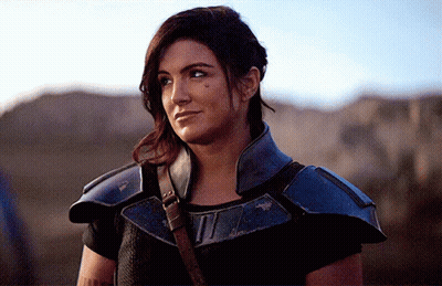 Woman In Black Shirt And Blue Armor Looking Sideways GIF