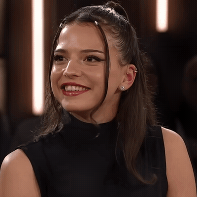 Woman In Black Shirt And Earrings Smiling GIF