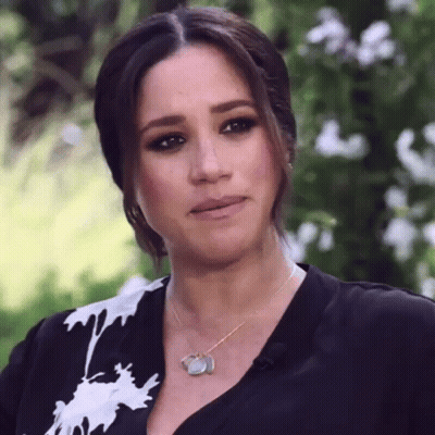 Woman In Black Shirt And Necklace Looking At Camera GIF