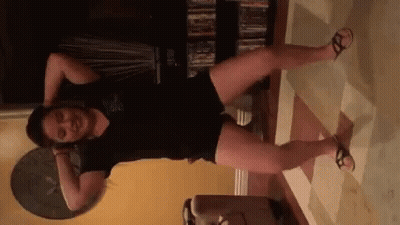 Woman in Black Shirt and Shorts Kneeling in Living Room