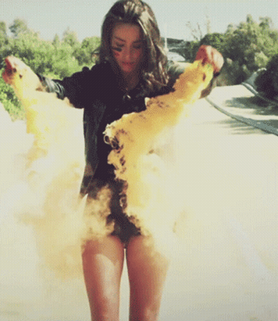 Woman In Black Shirt And Shorts Standing In Dust Cloud GIF