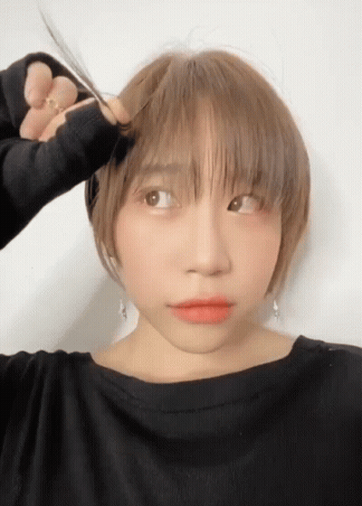 Woman In Black Shirt Cutting Hair With Scissors GIF