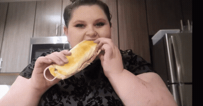 Woman in Black Shirt Eating Sandwich