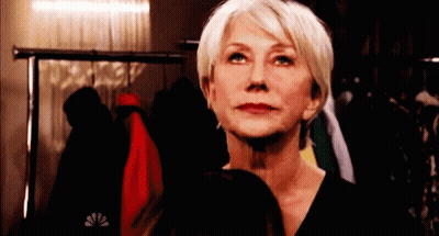 Woman In Black Shirt In Front Of Clothes Rack GIF