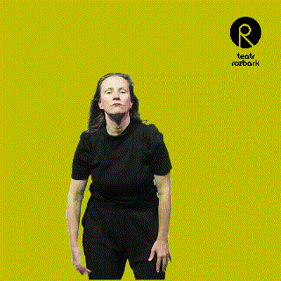 Woman In Black Shirt In Front Of Teatro Rozbark Logo GIF