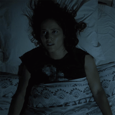 Woman In Black Shirt Lying In Bed Eyes Closed GIF