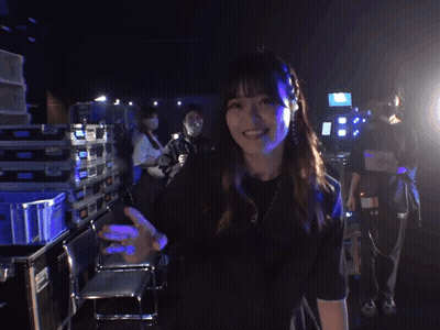 Woman In Black Shirt Smiling And Waving GIF