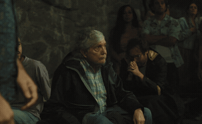 Woman In Black Shirt With Daisies In Crowd GIF