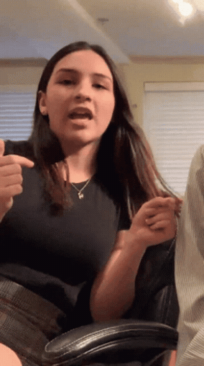 Woman In Black Shirt With P Necklace GIF