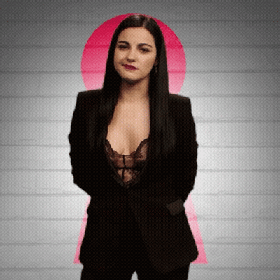 Woman In Black Suit And Lace Bra In Front Of Pink Keyhole GIF
