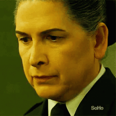 Woman In Black Suit And Tie Looking At Camera GIF