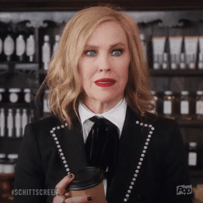 Woman In Black Suit Holding Coffee GIF