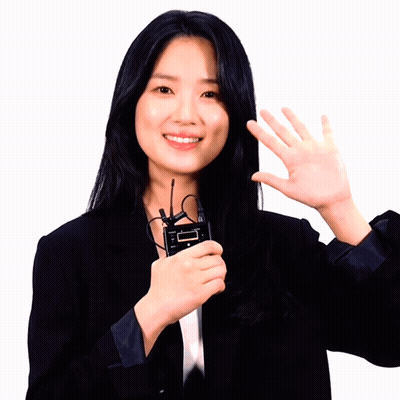Woman In Black Suit Holding Device Saying I'm GIF