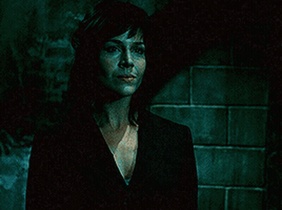 Woman In Black Suit In Dark Room GIF