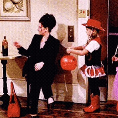 Woman In Black Suit Next To Girl In Cowboy Hat GIF