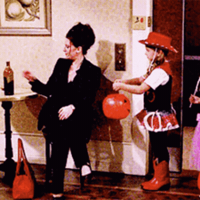 Woman In Black Suit Next To Girl In Red Hat GIF