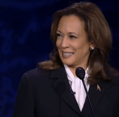 Woman In Black Suit Smiling At Microphone GIF