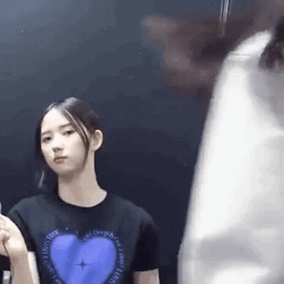 Woman In Black T-Shirt With Blue Heart Next To Man GIF