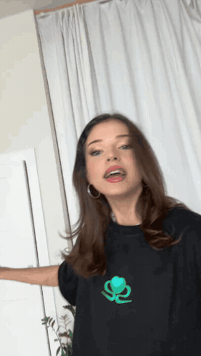 Woman In Black T-Shirt With Green Logo GIF