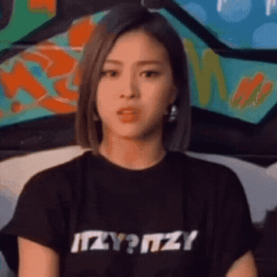 Woman In Black T-Shirt With Itzy Looking At Camera GIF
