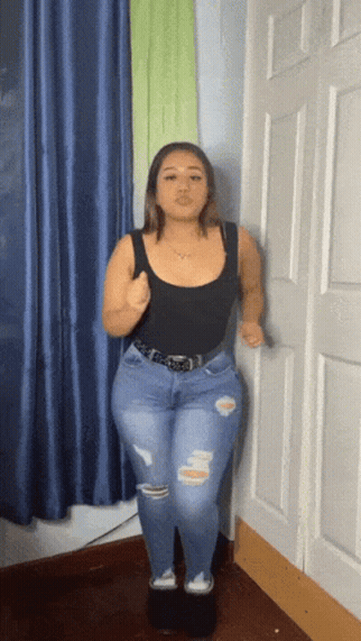Woman In Black Tank Top And Blue Jeans Standing In Room GIF