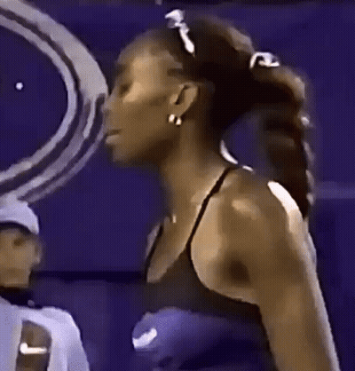 Woman In Black Tank Top And Earrings Against Purple Background GIF