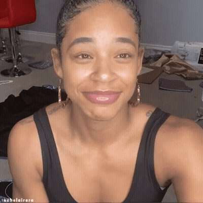 Woman In Black Tank Top And Gold Hoop Earrings Smiling GIF