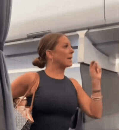 Woman In Black Tank Top Holding Purse In Airplane GIF