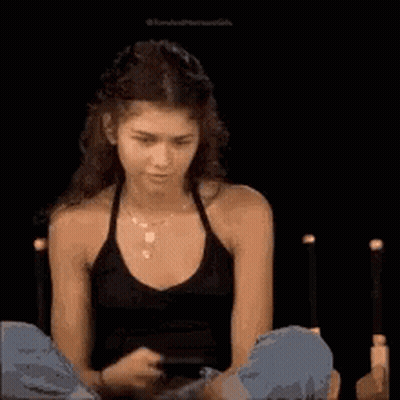 Woman In Black Tank Top Looking At Phone GIF