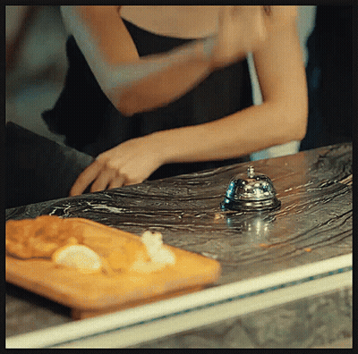 Woman In Black Tank Top Reaching For Bell GIF
